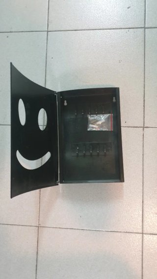 Caja de llaves negra con cara sonriente