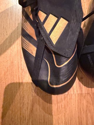 Botas de fútbol negras y doradas de  Bellingam