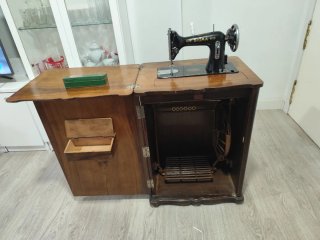Máquina de coser antigua en mueble de madera