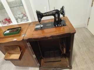 Máquina de coser antigua en mueble de madera