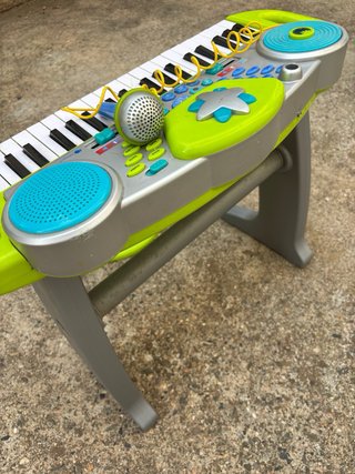 Piano de juguete con micrófono y taburete