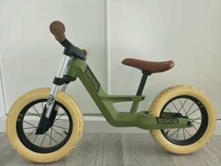 Bicicleta de equilibrio verde con bolso