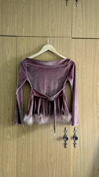 Blusa de terciopelo con plumas y cuello barco