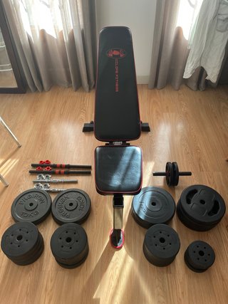 Banco de gimnasio, discos y mancuernas