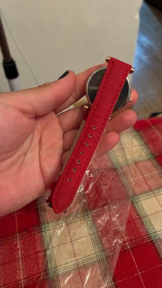 Reloj de pulsera dorado con correa roja