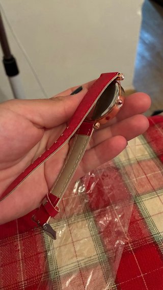 Reloj de pulsera dorado con correa roja