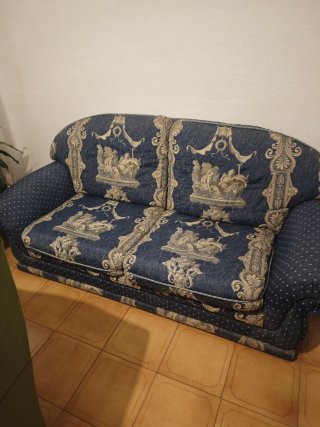Sofá de tela azul con estampado clásico.
