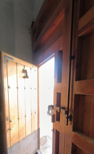 Puerta de madera rústica con herrajes