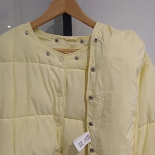 Plumífero  amarillo ligero de peso.