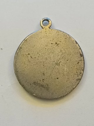 Medalla religiosa antigua con restos dorados