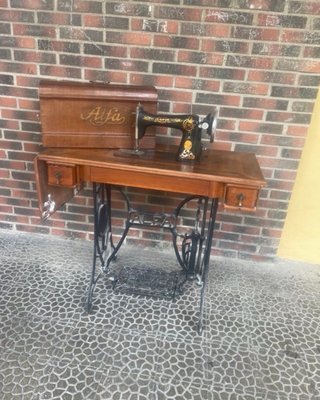 Máquina de coser Alfa antigua con mueble