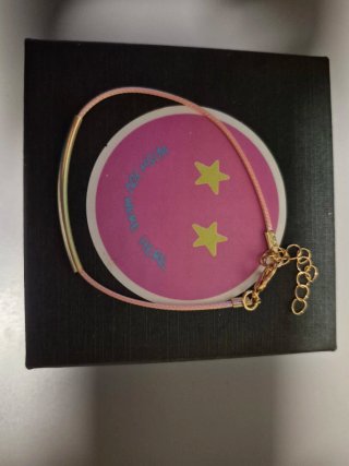 Pulsera de cuerda rosa y detalles dorados