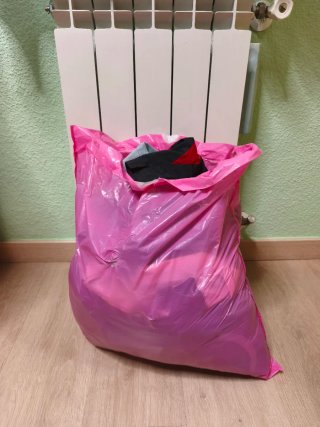 Bolsa grande de ropa variada de hombre.