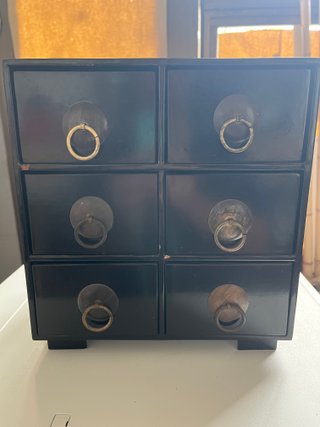Mueble de cajones negro con tiradores dorados