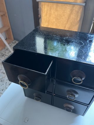Mueble de cajones negro con tiradores dorados