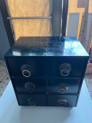 Mueble de cajones negro con tiradores dorados