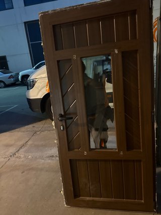 Puerta de entrada marrón con cristal