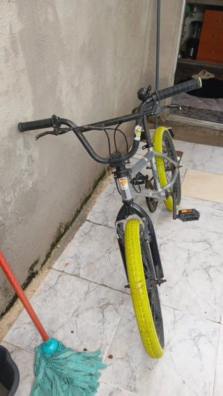 Bicicleta BMX plateada con ruedas amarillas
