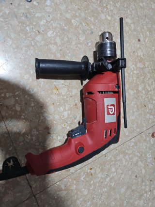 Taladro con cable rojo.