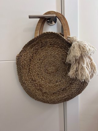 Bolso redondo de yute con asas de madera