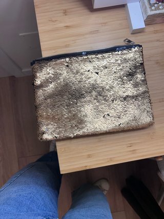 Cartera de lentejuelas en dorado y negro.