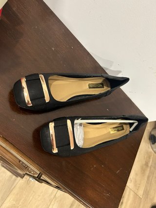 Zapatos planos negros con detalle dorado