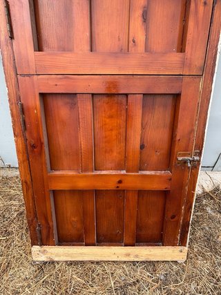 Puerta principal de madera antigua con herrajes