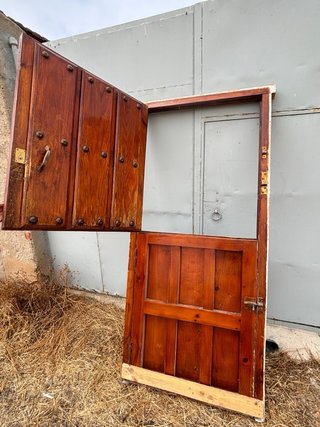 Puerta principal de madera antigua con herrajes