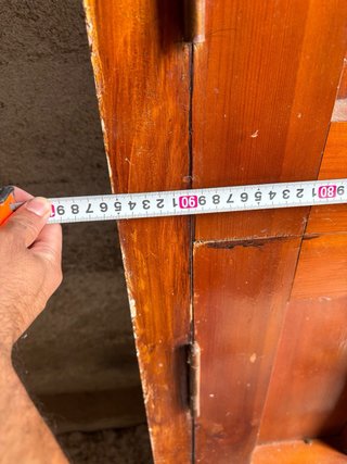 Puerta principal de madera antigua con herrajes