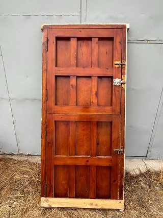 Puerta principal de madera antigua con herrajes