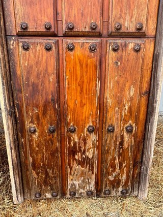 Puerta principal de madera antigua con herrajes