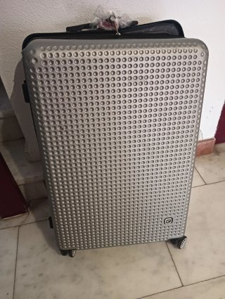Maleta de viaje plateada con  4 ruedas