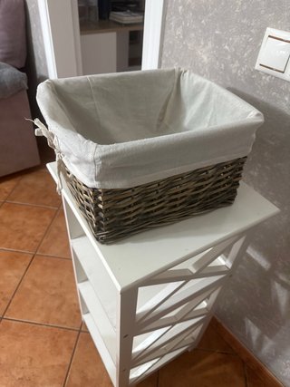 Mesa auxiliar de madera y cesto de mimbre.