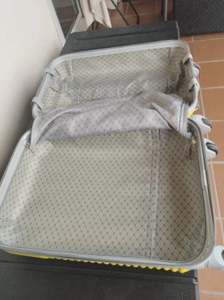 Maleta pequeña amarilla con ruedas.