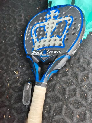 Pala de pádel negra y azul pequeño golpe