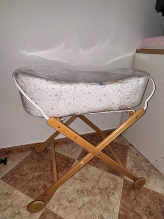 Mini cuna de mimbre con estructura de madera.