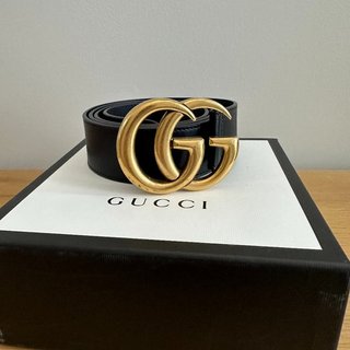 Cinturón Gucci GG negro y dorado para mujer