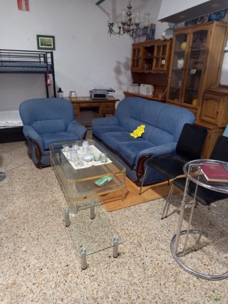 Sofá y sillón azul con mesa de cristal