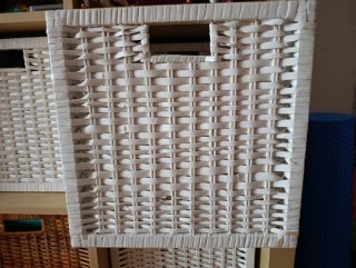 Caja de almacenaje de mimbre y una puerta madera