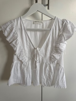 Blusa blanca con volantes y lazada