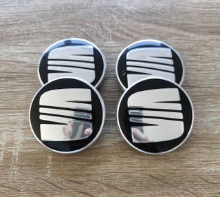 TAPABUJES SEAT 56mm NEGROS CON EMBLEMA PLATA