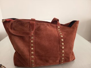 Bolso de piel marrón con tachuelas doradas