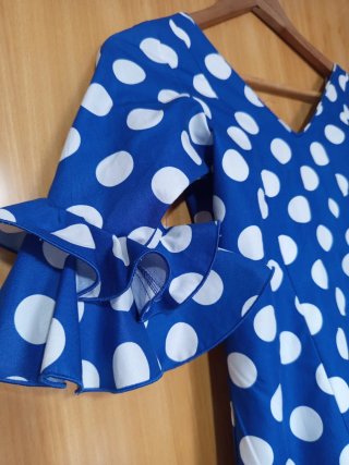 Traje de flamenca azul con lunares blancos.