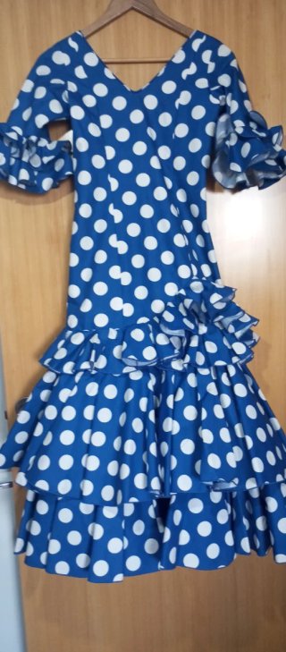 Traje de flamenca azul con lunares blancos.