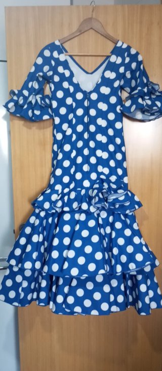 Traje de flamenca azul con lunares blancos.