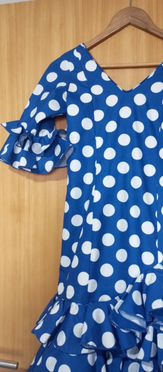 Traje de flamenca azul con lunares blancos.