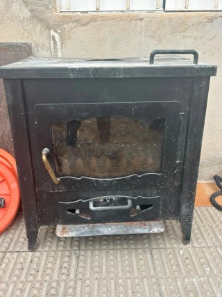 Estufa de leña negra con puerta de cristal