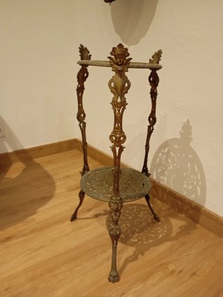 Mesa auxiliar antigua de metal dorada.