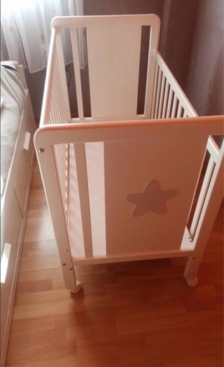 Cuna de bebé blanca con detalle de estrella