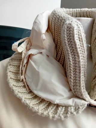 Piumino lungo beige con dettagli in maglia